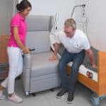 Transfer vom Bett in den Pflegesessel mit Aufstehhilfe