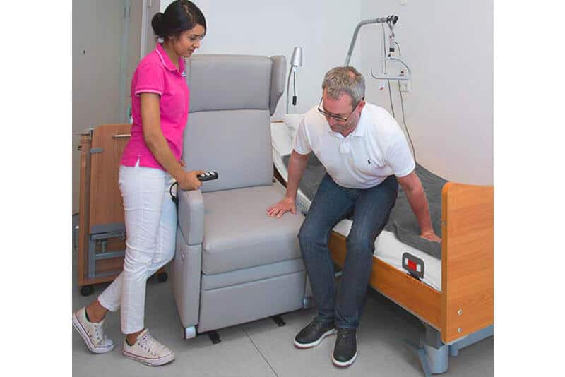 Transfer vom Bett in den Pflegesessel mit Aufstehhilfe